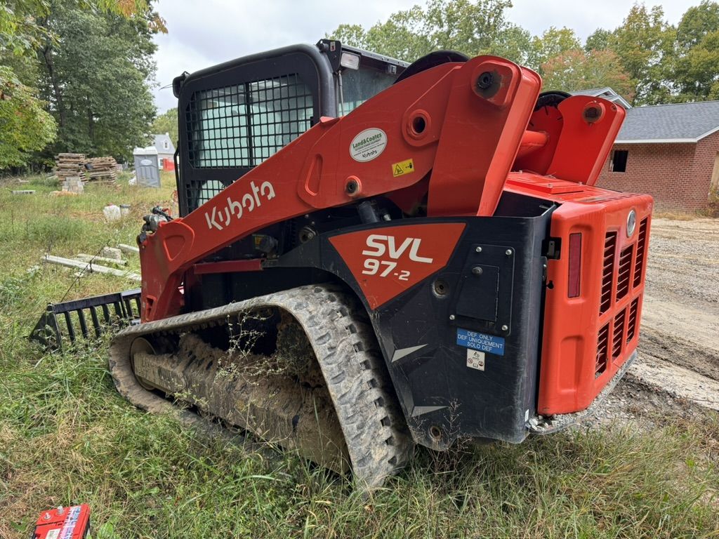Home Free's Kubota SVL97-2 compact track loader with a grapple rake